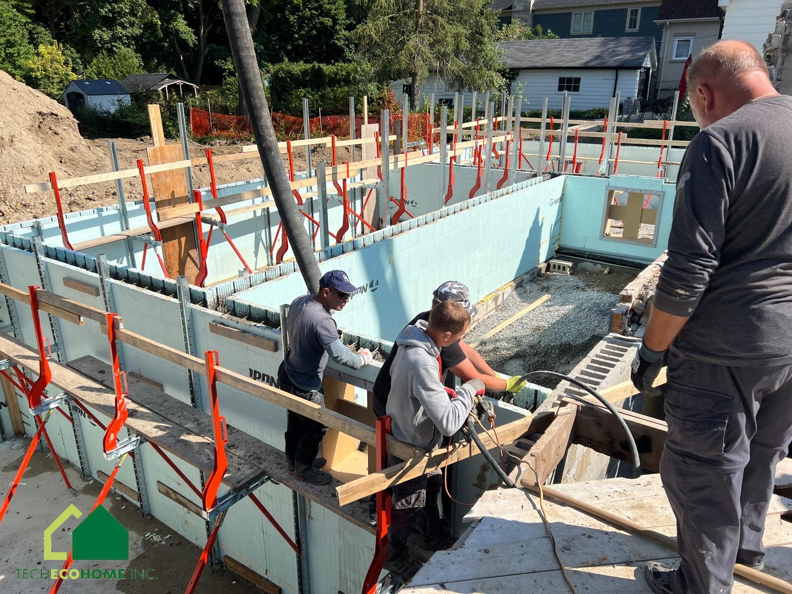 TECHECOHOME crew placing concrete into braced ICF walls on a residential foundation